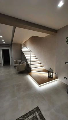 a living room filled with lots of furniture next to a stair leading up to the top floor