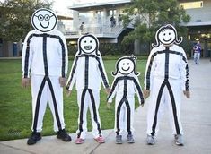 three adults and two children dressed up in black and white costumes with faces painted on them