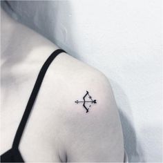 a woman's shoulder with an arrow tattoo on the left side of her arm