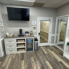 the inside of an office with white cabinets and glass doors