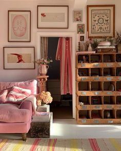 an instagram photo of a living room with pink furniture and pictures on the wall