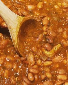 a wooden spoon stirring beans in a pot