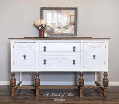 a white dresser sitting in front of a mirror on top of a hard wood floor