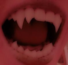 an open mouth with white teeth and sharp teeth