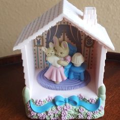 there is a small figurine on the table in front of a doll house