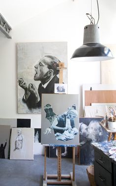 an artist's studio with paintings and lamps