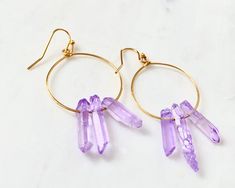 Raw purple quartz crystal points in gold or silver hoop earrings with French hooks. Perfect little boho look. Light weight and easy to wear. Add these to your boho outfits and make a 💜Healing clear quartz Crystal property has been know for centuries to restore balance in the body. -Options- 30mm as shown 21 gauge hoops Total drop Length: 2.3 inches 14k Gold filled hoops Sterling silver hoops Gold plated hoops Silver plated hoops All comes with hooks Simple, Dainty, Delicate, yet so Elegant and Trendy Hoop Jewelry For Jewelry Making, Trendy Small Hoop Purple Jewelry, Trendy Purple Small Hoop Jewelry, Bohemian Purple Hoop Earrings, Spiritual Hoop Earrings With Ear Wire, Bohemian Amethyst Drop Earrings, Trendy Purple Hoop Jewelry, Purple Bohemian Hoop Earrings, Adjustable Small Hoop Gemstone Jewelry