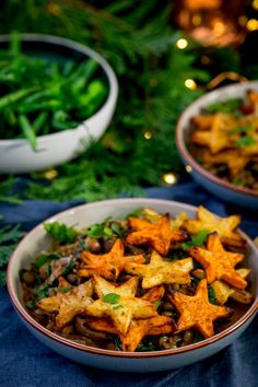 two bowls filled with food on top of a blue table cloth next to christmas decorations