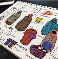 an open notebook with drawings of jackets on it