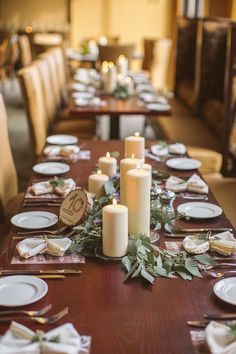 the table is set with candles, plates and napkins for dinner guests to enjoy