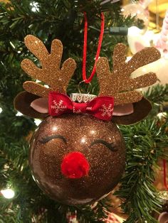 a christmas ornament hanging from a tree with reindeer's head on it