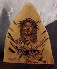 an image of jesus holding the cross on top of a wooden triangle shaped object with two hands