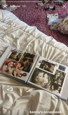 three books are open on a bed with white sheets and pink carpeted flooring