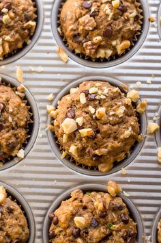 chocolate chip muffins in a baking pan with nuts and other toppings on top