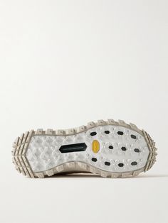 the sole of a white shoe with black and yellow accents on it's outstep