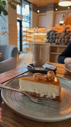 a piece of cheesecake sitting on top of a plate next to a cup of coffee