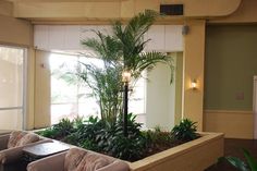 a living room filled with lots of furniture next to a planter on the floor