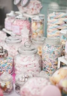 many jars filled with different types of candy