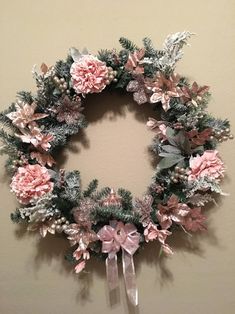 a wreath with pink flowers hanging on the wall