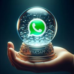 a person's hand holding a snow globe with whatsapp on it