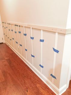 an unfinished room with blue tape on the wall and wood flooring in place for paint