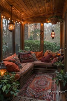 a covered porch with lots of plants and lights hanging from it's ceiling above the couch