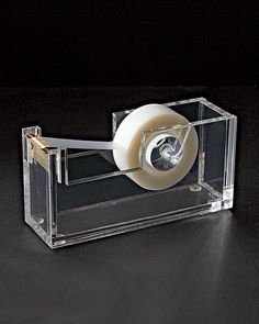 a clear box with a roll of toilet paper in it on a black table top