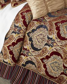 the comforter is made up with red, blue and gold paisley designs on it