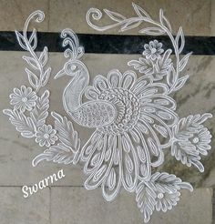 an intricately designed peacock is shown on the floor in front of a marble wall