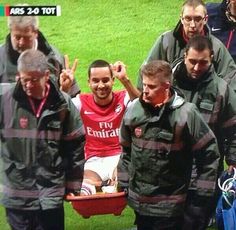 the soccer players are being carried on a stretcher by two men in red and black jackets