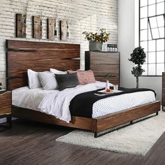 a large bed sitting next to a window in a bedroom on top of a wooden floor