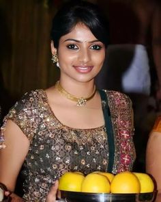 a woman holding a bowl full of lemons