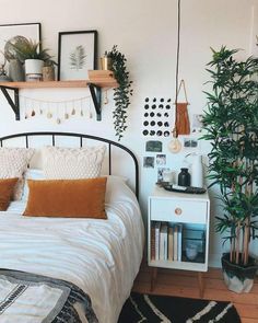 a bed room with a neatly made bed and some plants