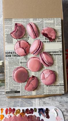 there are some pink donuts that have been cut in half and placed on top of a newspaper