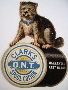 a dog sitting on top of a spool of yarn next to a sign that says clark's trade o n t