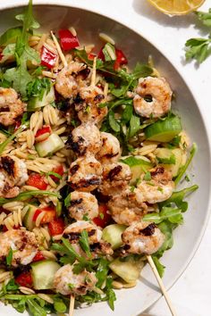 a white bowl filled with pasta salad and shrimp