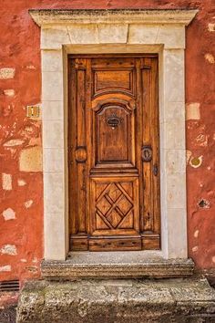 an old wooden door in front of a red brick building with stone steps and windows