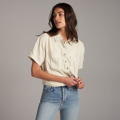 With a boxy silhouette and relaxed fit and made from naturally anti-microbial 100% linen, The Sloane is the perfect easy and breezy summer blouse. Plenty of Rowan details such as herringbone cotton twill tape on the inside front placket for a contrasting reveal when worn with open buttons, our two-hole signature metal buttons, and patch chest pockets. The wide center back box pleat with signature stitch details secured at the top and bottom give movement and flow while holding the Sloane's shape Casual Cropped Blouse With Pockets, Effortless Summer Blouse With Pockets, Spring Flax Relaxed Fit Blouse, Short Sleeve Linen Tops For Daywear, Linen Short Sleeve Tops For Daywear, Effortless Linen Tops For Day Out, Summer Blouse With Pockets For Everyday Wear, Spring Linen Tops With Pockets, Casual Flax-colored Cotton Blouse