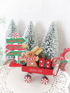 a teddy bear riding in a red wagon with christmas decorations on the front and sides