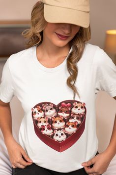 Step into a world of cuteness with our unique Cartoon Hamster Heart Box T-Shirt! Crafted from premium soft cotton, this shirt provides comfort that lasts all day long. The delightful graphic featuring cartoon hamsters nestled in a heart-shaped box is sure to capture hearts and spark conversations. This tee is a perfect blend of style and playfulness, making it an ideal gift for pet lovers of all ages. Suitable for both kids and adults, it comes in a range of sizes to ensure the perfect fit. Whet Casual T-shirt With Character Print As Gift, Casual T-shirt With Character Print For Gift, White Cartoon Print T-shirt For Gifts, White T-shirt With Cartoon Print For Gift, Cute Cartoon Print T-shirt As Gift, Cute Cartoon Print T-shirt For Gift, Short Sleeve Cartoon Print Top As Gift, Kawaii Short Sleeve Tops For Gift, Kawaii Graphic Print T-shirt Gift