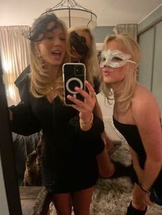 two women are taking a selfie in front of a mirror while wearing blindfolds