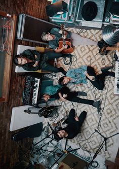 a group of people standing next to each other in front of musical instruments and keyboards