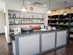 the front desk of a pharmacy with medicine bottles on it and shelves full of medicines