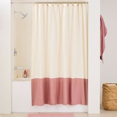 a bathroom with a pink rug and shower curtain