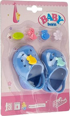 a pair of blue baby shoes sitting on top of a plastic package with rubber feet