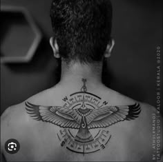 the back of a man's neck with an eagle and compass tattoo on it