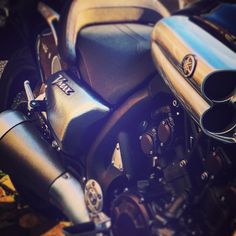 a close up of a motorcycle parked on the ground with it's exhaust pipe sticking out