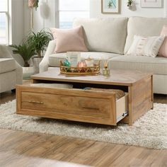 a living room with white couches and wooden coffee table in front of large windows