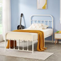 a white bed with a guitar on the headboard and foot board in front of it