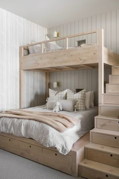 there is a bunk bed with stairs in the room and pillows on the bottom shelf